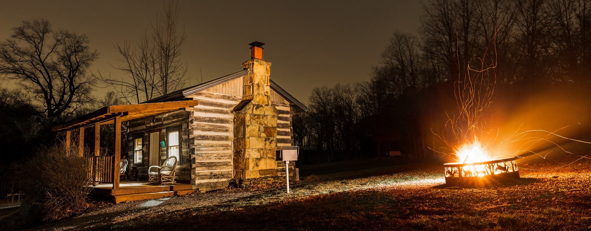 rustic cabin and outdoor fire pit at night